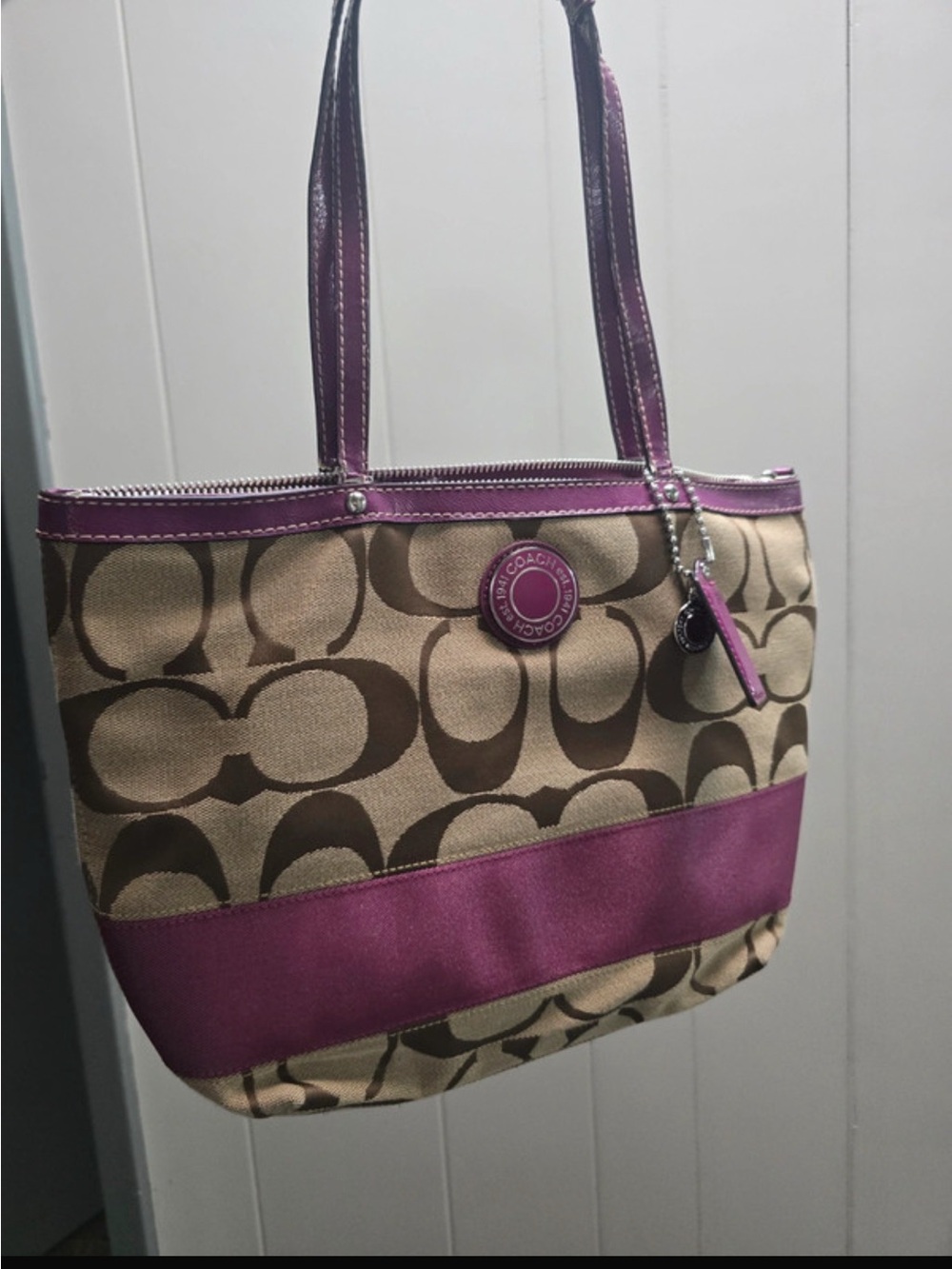 Coach Beige Signature Canvas Tote with Purple Trim straps are worn shown in pic
